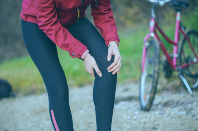 Woman with cycling injury next to bike