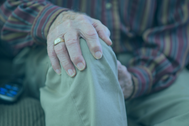 Older man holding knee in pain from rheumatoid arthritis
