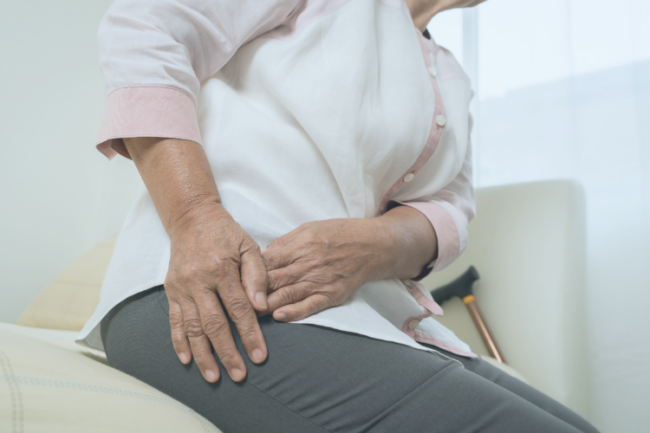 Older woman holding hip from arthritis pain