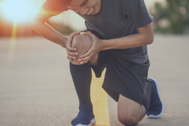 Patellar Tendonitis Causes Symptoms Diagnosis Treatment Prevention Man running holding knee in pain