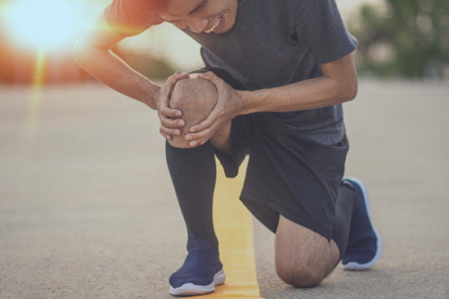 Runner holding knee in pain